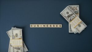 Top view of dollar bills and 'businesses' letter tiles symbolizing financial success.